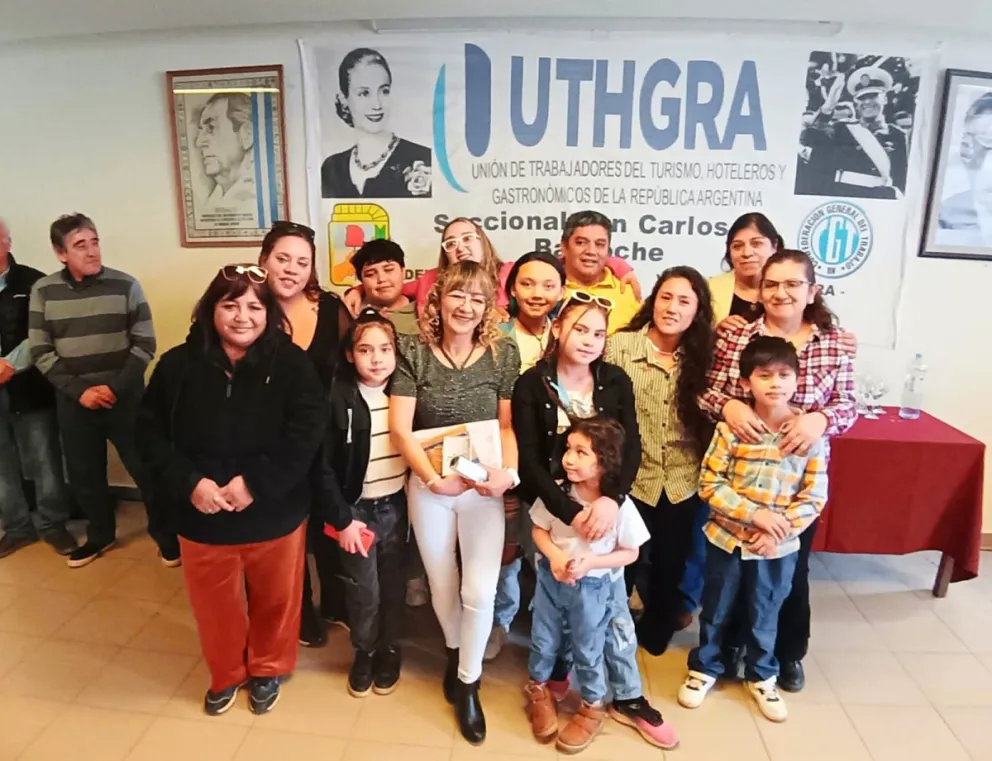 Una trabajadora recibiendo el diploma junto a su familia. Crédito: UTHGRA.